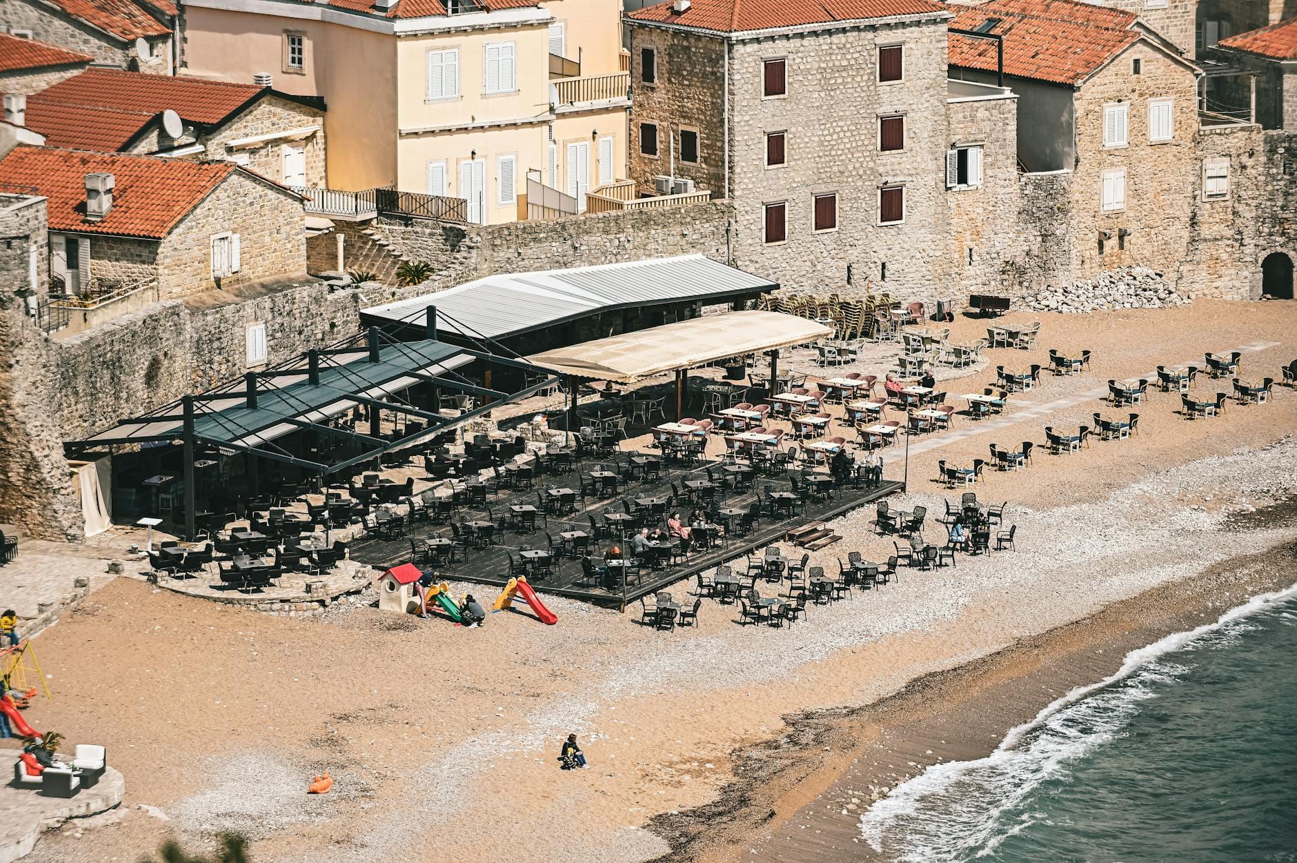Pusty nadmorski lokal i kamienne zabudowania w chorwackim miasteczku
