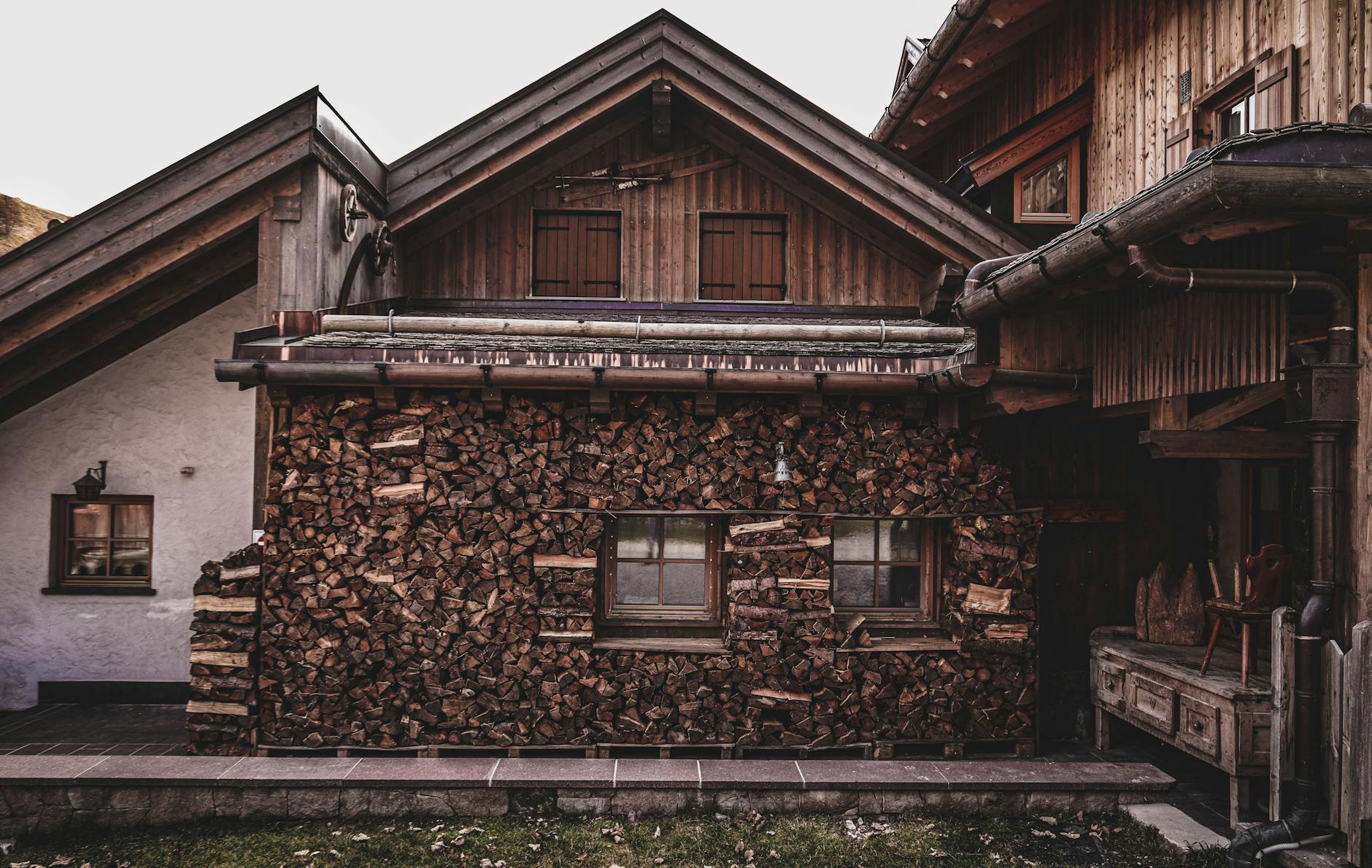 Drewniany domek z równo ułożonym drewnem opałowym przy ścianie