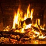 Płonący ogień w kominku podczas nocnego palenia w salonie