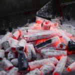 Żarzące się sześciokątne brykiety z otworami na metalowym ruszcie